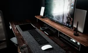 Bureau de travail avec un grand écran pour retouche photo, tablette, clavier et souris.