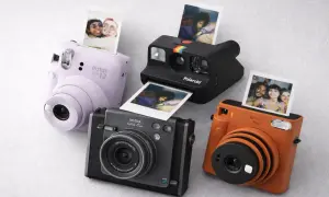 Quatre appareils photo instantanés, dont un Instax Mini 12 lilas, un Polaroid noir et un Instax orange, sortent des photos de souvenirs.