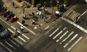 Un homme sur une planche de surf traverse une rue animée, une scène capturée par Romain Laurent.