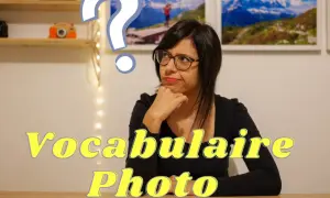 Une femme réfléchit à un point d'interrogation, devant des photos de montagnes et des appareils photo. Le texte "Vocabulaire Photo" apparaît.
