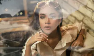 Jeune femme au regard intense, lunettes sur la tête, avec un effet vitre photoshop créant une atmosphère rêveuse.