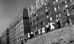 Une chaîne de jeunes gens se tient la main devant des immeubles, une scène de joie capturée dans cette photo célèbre.