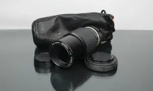 Objectif Zoom-NIKKOR 80-200mm f/4.5 avec son étui en cuir noir, prêt pour une nouvelle aventure photographique. Un classique Nikon.