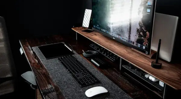 Bureau de travail avec un grand écran pour retouche photo, tablette, clavier et souris.