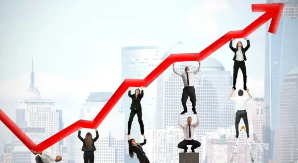 Une équipe d'affaires soutient une flèche de graphique rouge en hausse, symbolisant la croissance du commerce.