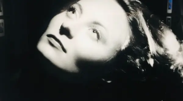 Portrait dramatique d'une femme, éclairée par le bas, évoquant l'histoire du Studio Harcourt.