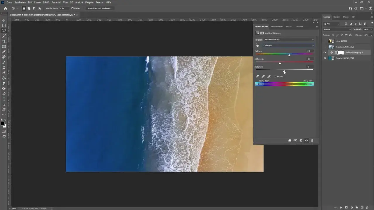 Un homme ajuste les curseurs de teinte, saturation et luminosité dans Photoshop pour changer la couleur d'une photo de plage.