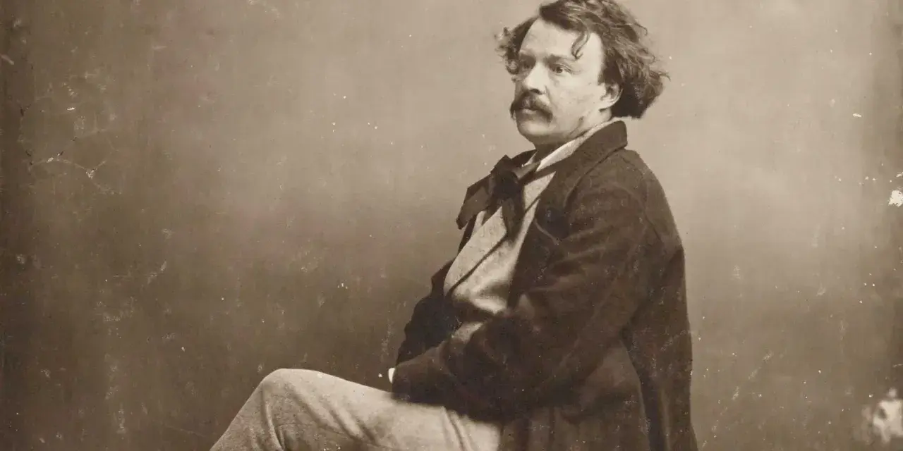 Portrait photographique 19ème siècle d'un homme à la moustache et aux cheveux bouclés, vêtu d'un manteau sombre et d'une chemise à nœud.