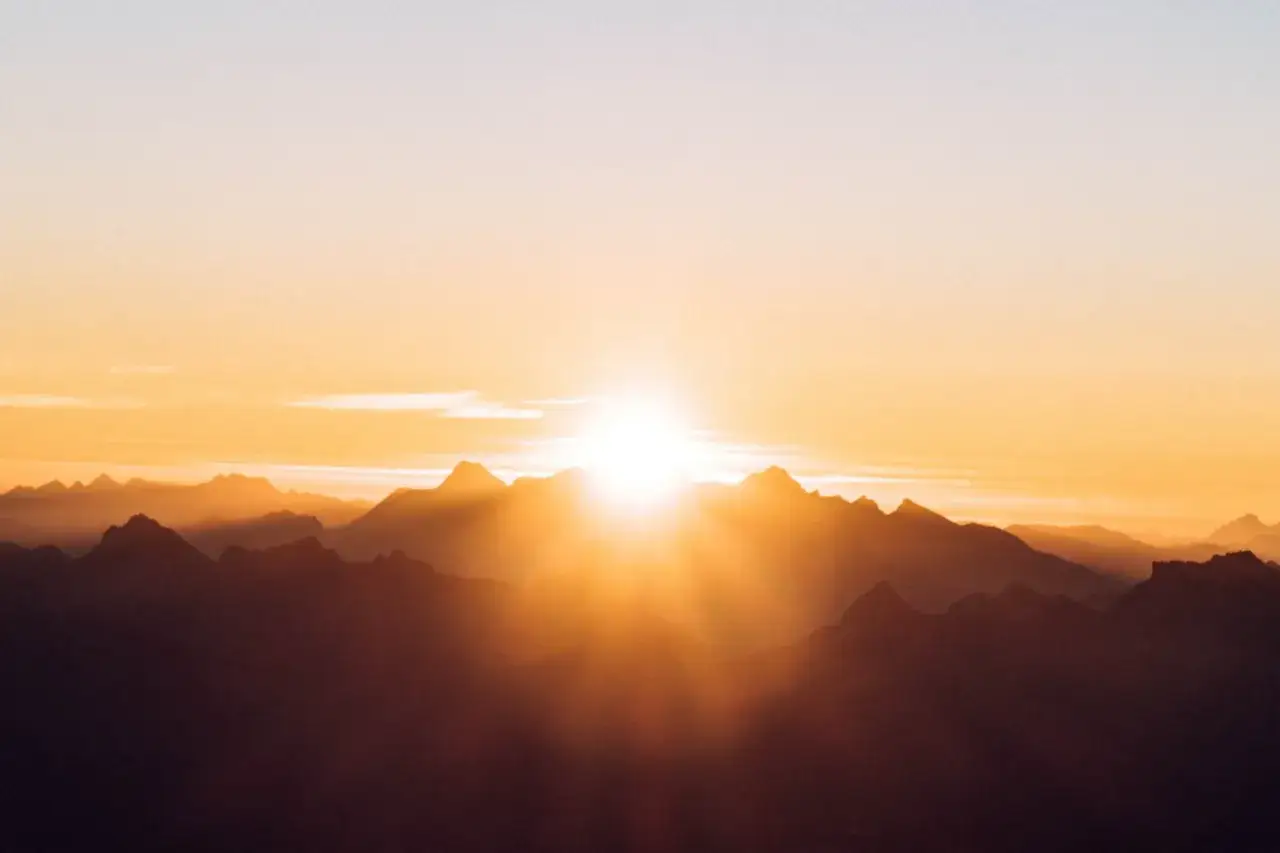Lever soleil sur les montagnes, une sc&egrave;ne parfaite pour apprendre comment prendre une belle photo. Les rayons dor&eacute;s illuminent les sommets.