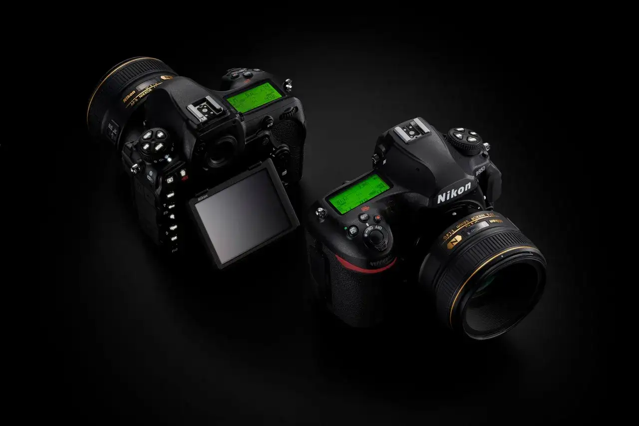 Deux reflex Nikon D850, dont la date de sortie a marqu&eacute; une &eacute;tape, sont pr&eacute;sent&eacute;s sur fond noir. L'un est ouvert, r&eacute;v&eacute;lant son &eacute;cran LCD articul&eacute;.