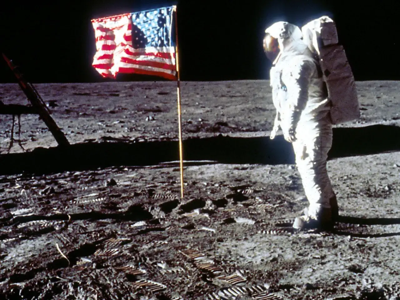 Un astronaute se tient pr&egrave;s du drapeau am&eacute;ricain sur la Lune. Une photo historique c&eacute;l&egrave;bre, grav&eacute;e dans le sol lunaire.