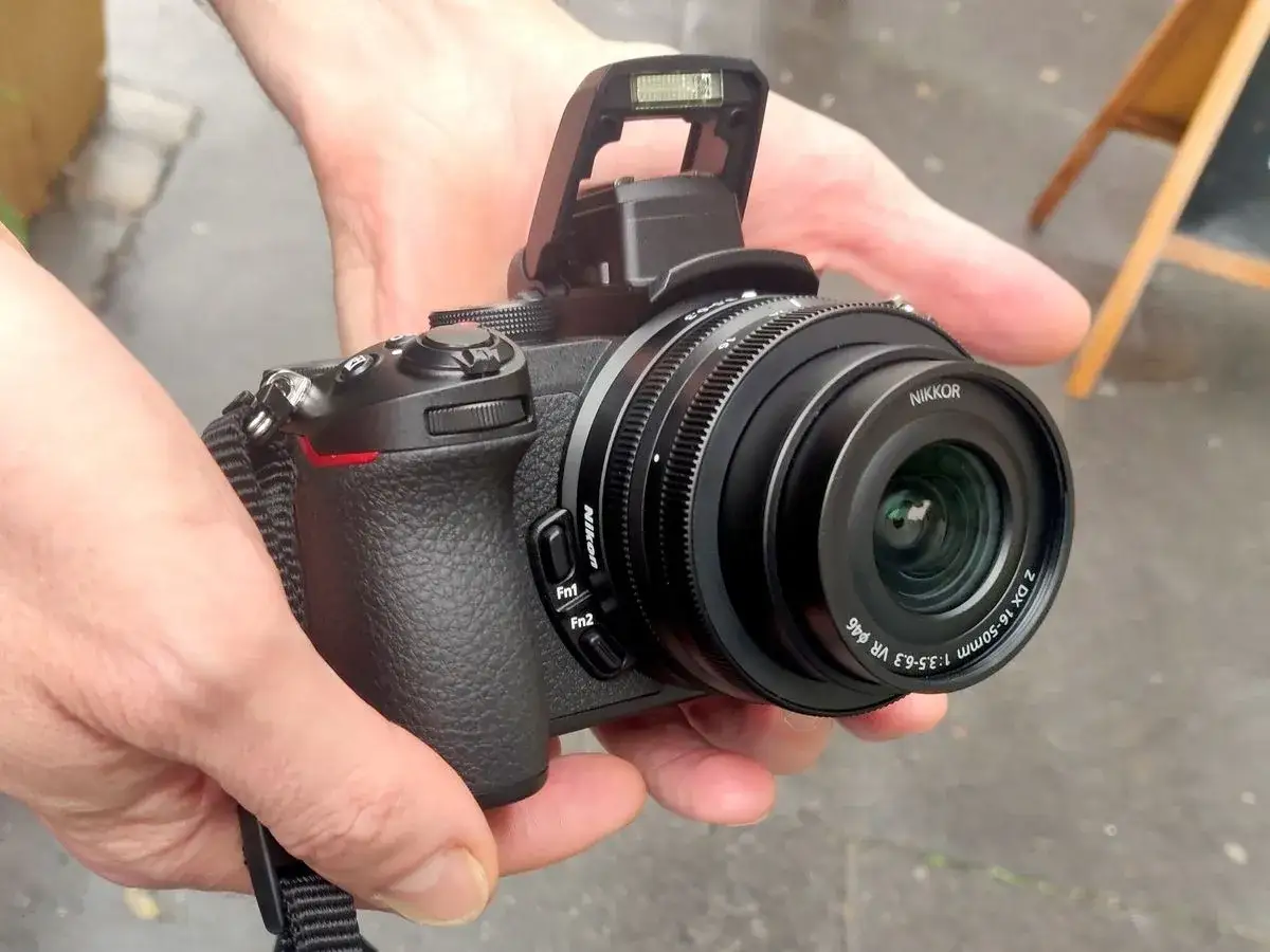 Un appareil photo Nikon Z50 tenu en main, prêt à capturer des moments. Mon avis : excellent pour débuter !