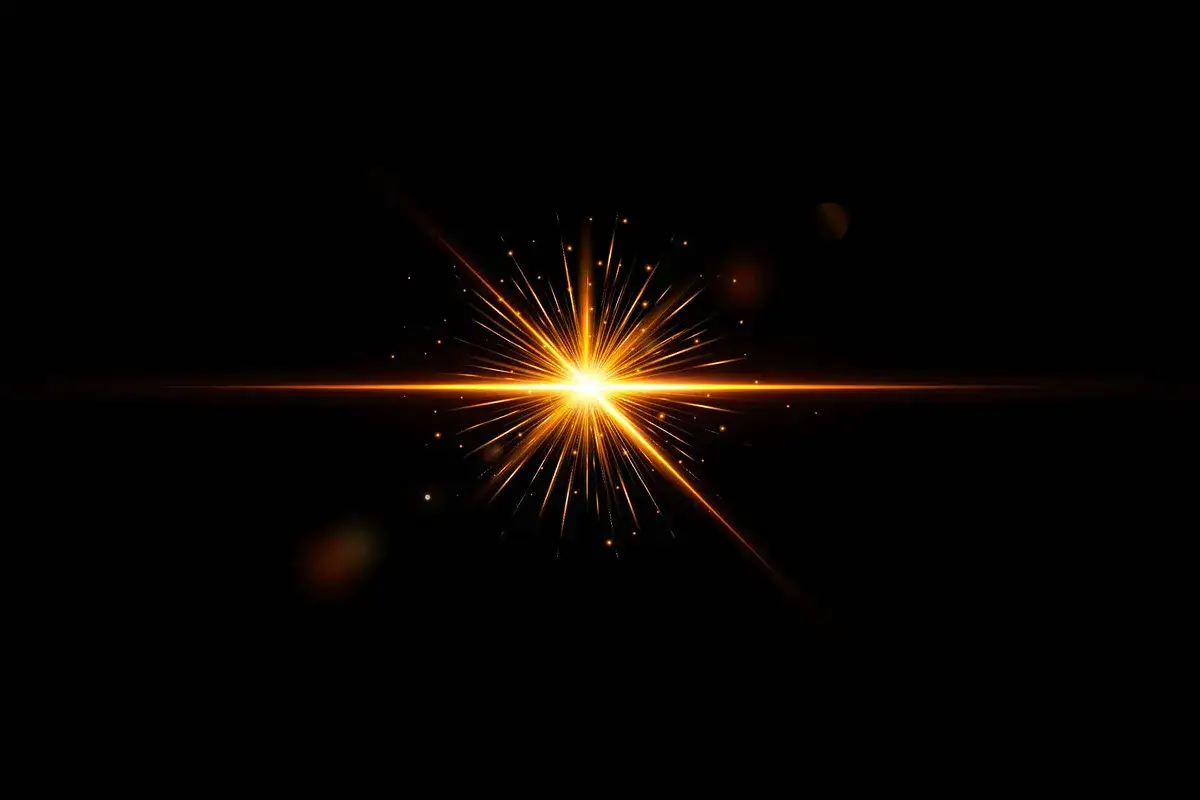 Un éclat lumineux orange, comme un flare photoshop, illumine un fond noir, avec des particules scintillantes.