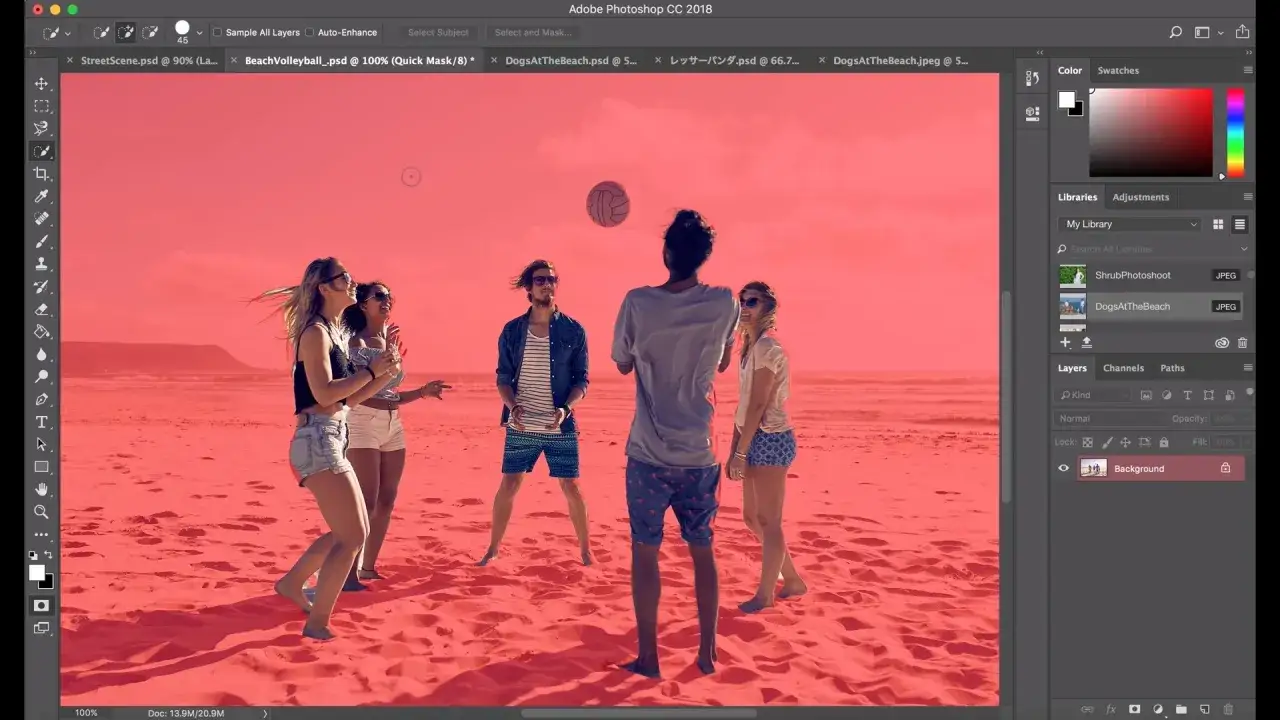 Un groupe d'amis joue au volleyball sur une plage, le ciel et le sable sont masqu&eacute;s en rouge, montrant l'utilisation de l'outil s&eacute;lection rapide Photoshop.