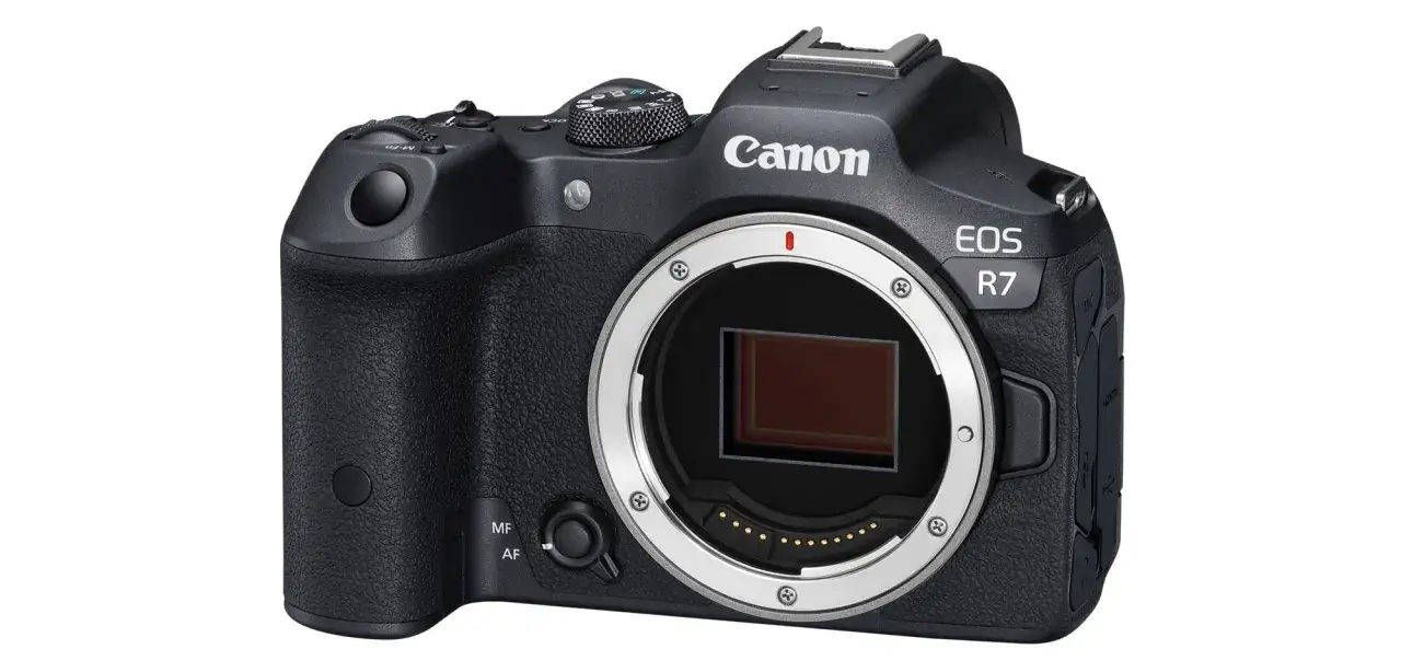 Appareil photo noir Canon EOS R7, vu de face, avec son objectif amovible.