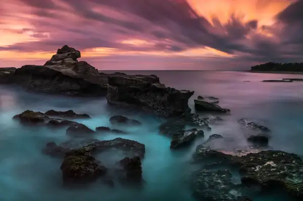Coucher de soleil sur la côte rocheuse, l'eau vaporeuse et les nuages filent. C'est ça, le HDR !