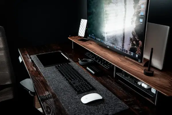 Bureau de travail avec un grand écran pour retouche photo, tablette, clavier et souris.