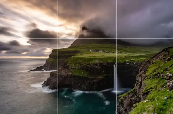 Paysage spectaculaire avec des falaises verdoyantes, une cascade tombant dans l'océan et un village pittoresque. La perspective accentue la beauté sauvage de ce lieu.