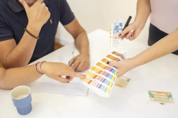 Des mains choisissent des couleurs sur un nuancier Pantone, lors d'une réunion de photo entreprises.